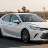Toyota Camry hybrid sedan running on highway with driver