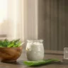 Fresh neem leaves and yogurt on a stylish desk representing a natural hair care mask.