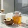 Fresh milk, honey, and banana on a stylish desk representing organic ingredients for a winter face pack.