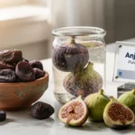Premium dried figs in a bowl and soaking in a glass jar arranged on a stylish desk representing healthy lifestyle ingredients.