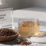 Raw flaxseeds and a jar of extracted gel arranged on a stylish desk representing natural skincare ingredients.